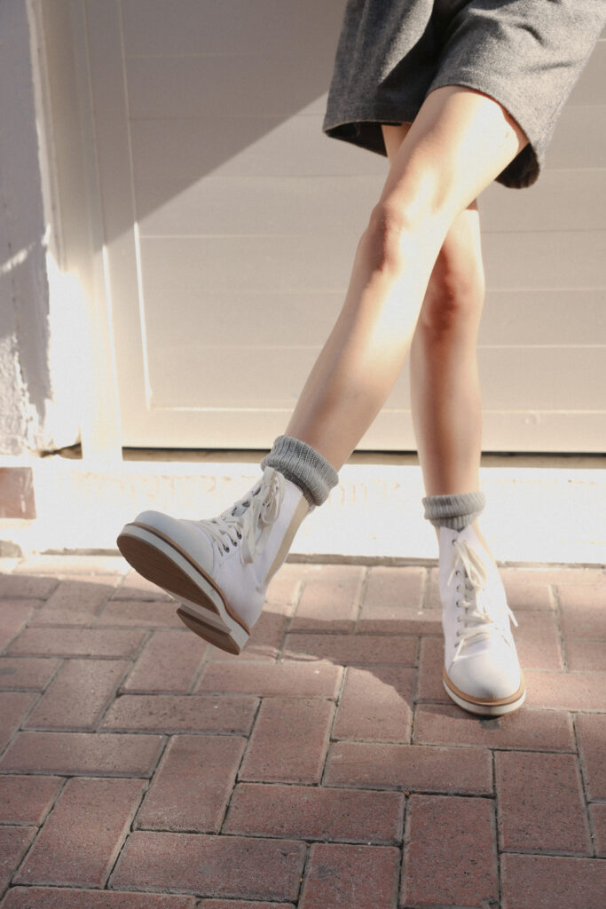Model wearing White Wind boots styled with socks and a skirt